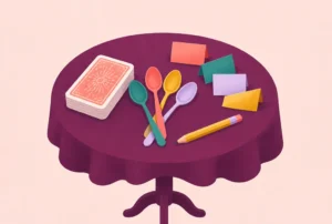 A small table with a deck of cards, spoons, a pencil and paper slips
